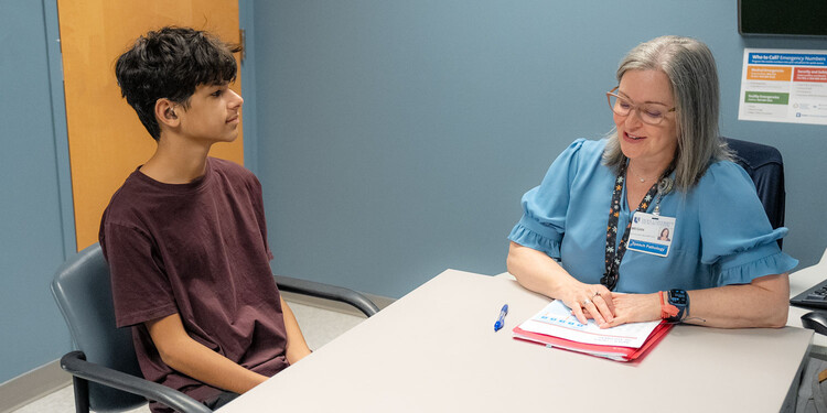 Andy Torres works with speech pathologist Megan Katz at a table